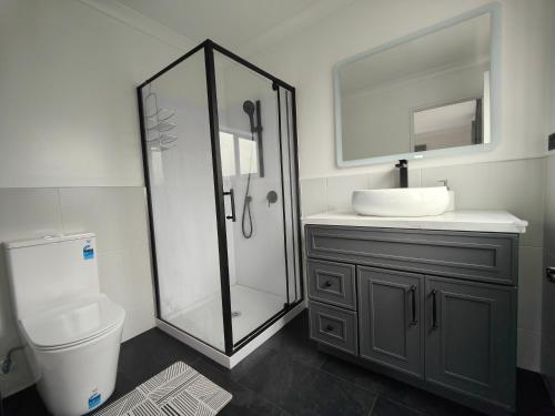 a bathroom with a shower and a toilet and a sink at Quality Stay Private Guest Room in Auckland in Auckland
