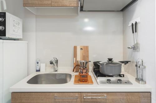 a kitchen with a sink and a pot on a stove at 川HOUSE黒門 in Osaka