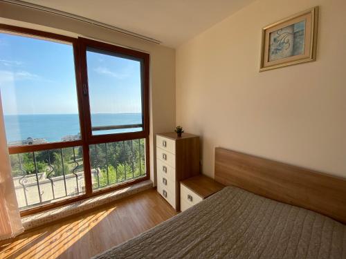 Sea view apartment in Sveti Vlas في إلينايت: غرفة نوم بسرير ونافذة كبيرة