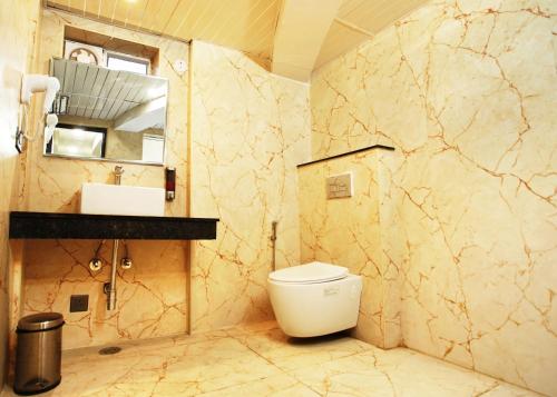 a bathroom with a toilet and a sink and a mirror at Dream Hotel - Richmond in Bengaluru