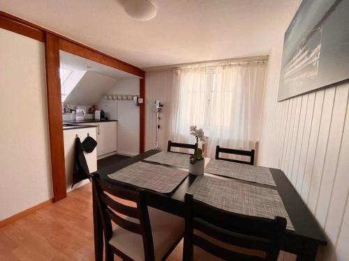 a dining room with a table and chairs and a kitchen at Apartment Romanshorn von Swisspartments in Romanshorn