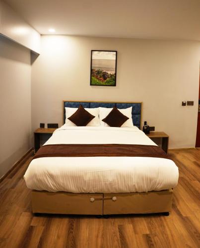 a bedroom with a large bed with wooden floors at Dream Hotel - Richmond in Bengaluru