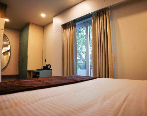 a bedroom with a bed and a large window at Dream Hotel - Richmond in Bengaluru