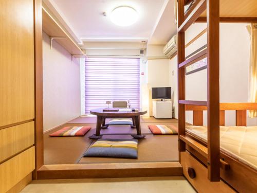 a room with a table and a bunk bed at Omotenashi Hostel Miyajima in Hatsukaichi
