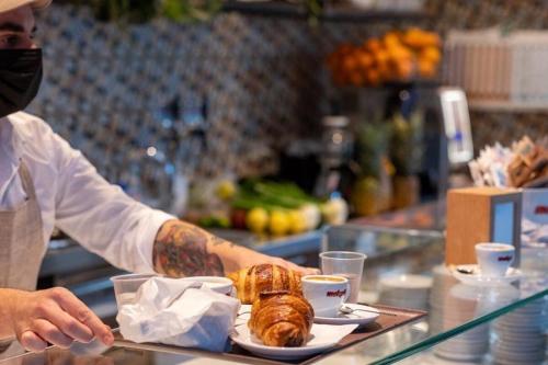 uma pessoa com uma máscara segurando uma bandeja de comida em Maison Patricia em Lecce