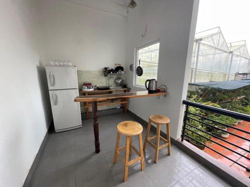La cuisine est équipée d'un comptoir, d'un réfrigérateur et de deux tabourets. dans l'établissement ViVu House2, à Da Thien