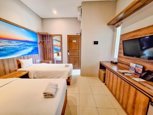 a hotel room with two beds and a flat screen tv at Sekuro Village Beach Resort in Jepara