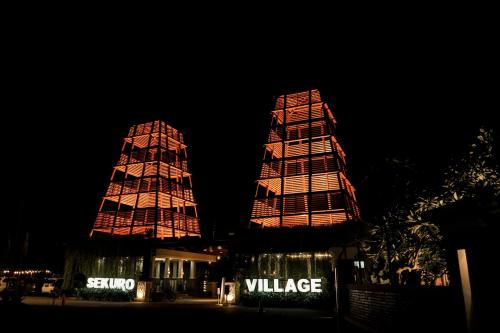 two tall buildings are lit up at night at Sekuro Village Beach Resort in Jepara