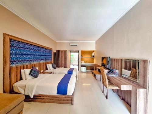 a hotel room with two beds and a desk at Sekuro Village Beach Resort in Jepara