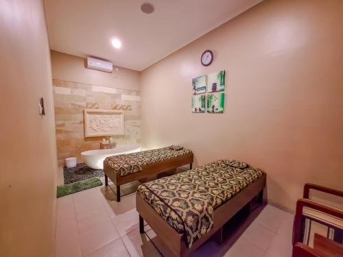a bathroom with two beds and a sink and a tub at Sekuro Village Beach Resort in Jepara