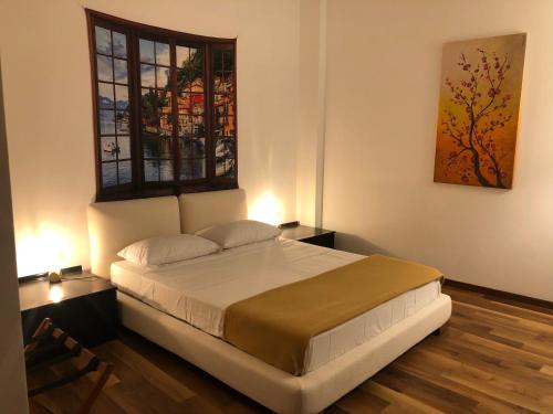 um quarto com uma cama grande e uma janela em Frane House em Lazise