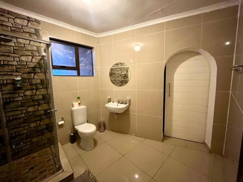un baño con inodoro y lavabo en Swane’s guesthouse, en Rustenburg