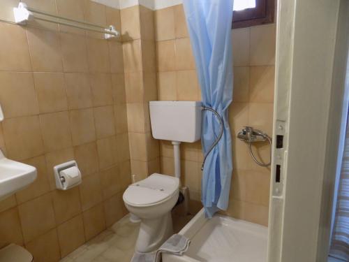 a bathroom with a toilet and a tub and a sink at Afrodite Spacious Apartments! in Agia Effimia