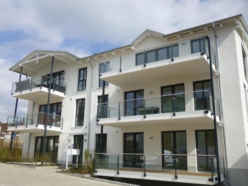 a white building with balconies on the side of it at Stella in der Villa Amelie am Meer in Sassnitz