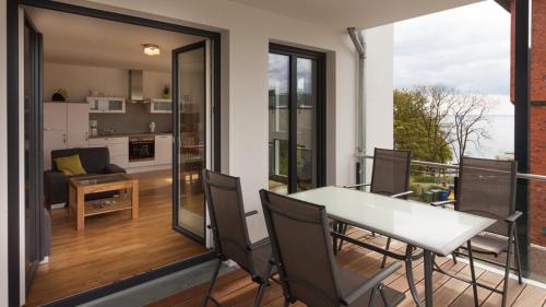 a balcony with a table and chairs and a living room at Stella in der Villa Amelie am Meer in Sassnitz