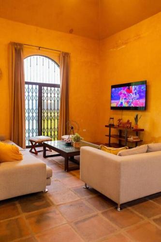 a living room with two couches and a tv at The Palm- A Luxury Villa in Retalhuleu