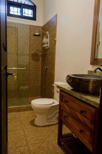 a bathroom with a toilet and a shower and a sink at The Palm- A Luxury Villa in Retalhuleu