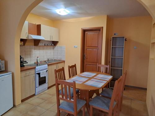 a kitchen with a table and chairs in a room at Rozmaring Apartmanok in Gyula