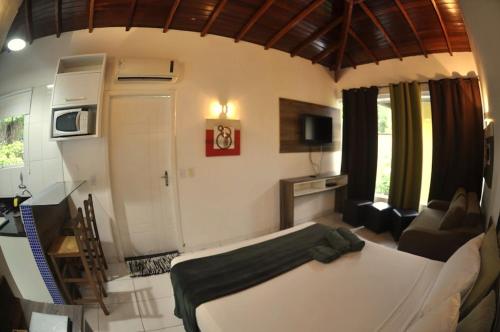 um quarto com uma cama e uma sala de estar em Pousada Jungle Beach Maresias em Maresias