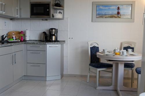a kitchen with a small table and a lighthouse at Appartement "Sonnenperle" in Heiligenhafen