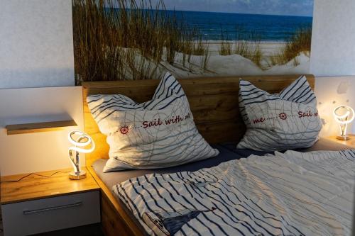 a bed with pillows and a picture of the beach at Appartement "Sonnenperle" in Heiligenhafen