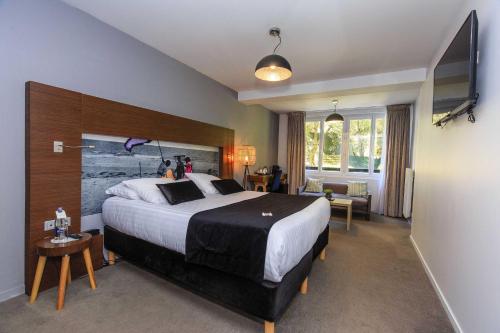 a hotel room with a large bed and a living room at Best Western Hôtel Garden and Spa in La Baule