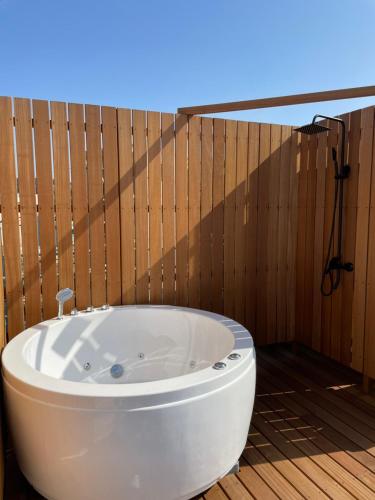 a bath tub in a bathroom with a wooden wall at 葉山THE TERRACE HOUSE in Hayama