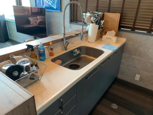 a kitchen with a sink and a counter top at 葉山THE TERRACE HOUSE in Hayama