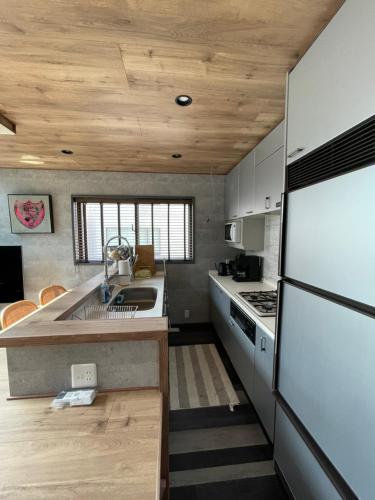 a kitchen with a refrigerator and a counter top at 葉山THE TERRACE HOUSE in Hayama