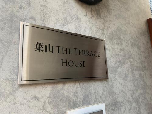 a sign for a terrace house on a wall at 葉山THE TERRACE HOUSE in Hayama