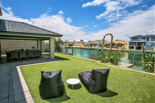 two black bags sitting on the grass in a yard at 2 Luxury Canal Holiday Homes - Sleep 28 in Mandurah