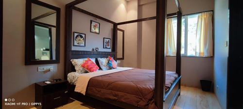 - une chambre avec un lit et un grand miroir dans l'établissement Khopoli XoXo Villa, à Khopoli