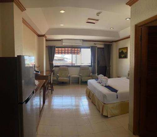 a hotel room with a bed and a living room at Seaview Sriracha Hotel in Si Racha
