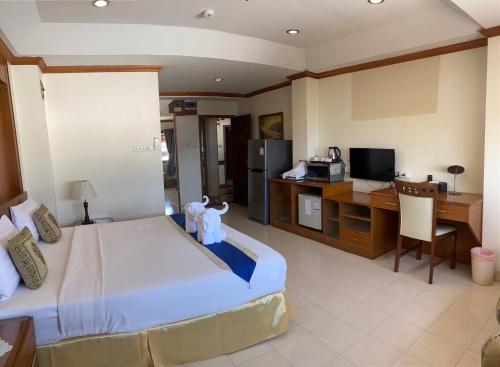 Habitación de hotel con cama grande y escritorio. en Seaview Sriracha Hotel, en Si Racha
