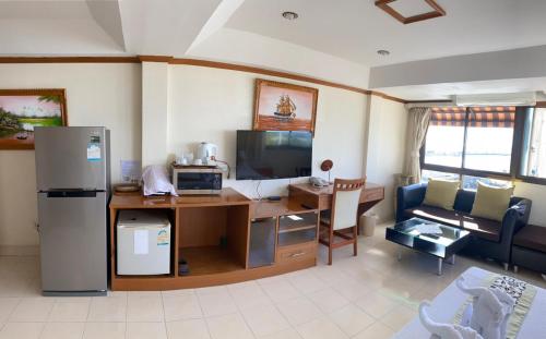 a kitchen and living room with a desk and a refrigerator at Seaview Sriracha Hotel in Si Racha