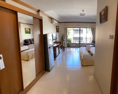 a living room with a refrigerator and a kitchen at Seaview Sriracha Hotel in Si Racha