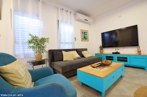 ein Wohnzimmer mit einem Sofa und einem TV in der Unterkunft Allen suite in Migdal