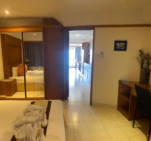 a living room with a room with a bed and a mirror at Seaview Sriracha Hotel in Si Racha