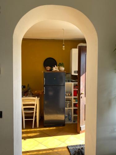 una cucina con frigorifero nero e tavolo di CASA PERMIRRA a Feltre