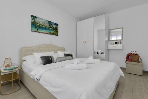 2 letti in una camera bianca con pareti bianche di Hortenzija Apartments a Makarska