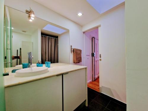 a bathroom with a sink and a large mirror at Mouraria Studios & Flats by Lisbon Village Apartments in Lisbon