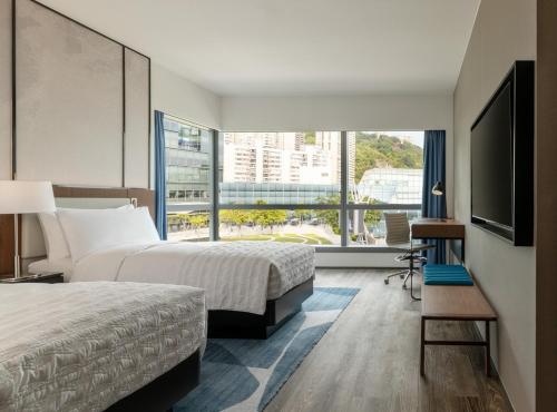 a hotel room with two beds and a large window at Le Méridien Hong Kong, Cyberport in Hong Kong