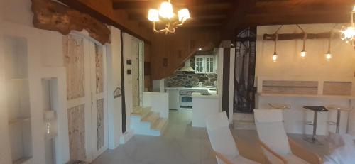 a kitchen with white appliances and white chairs in a room at Relax Holistic House in Potamiá