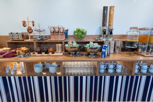 a shelf filled with plates and bowls of food at Das Schreder Hotel in Munich
