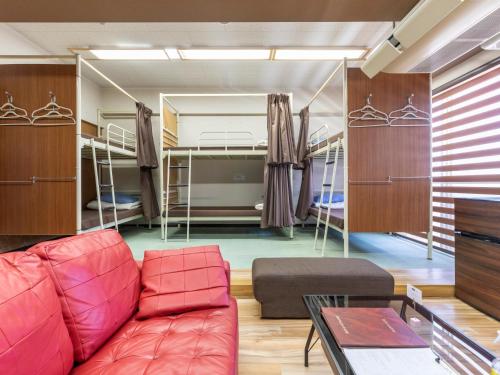 a living room with a couch and two bunk beds at Omotenashi Hostel Miyajima in Hatsukaichi