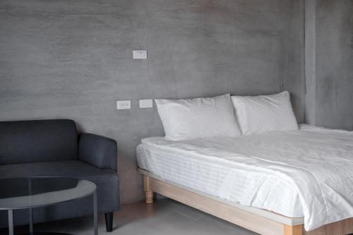 a bed and a chair in a room at Sun Island in Xiaoliuqiu