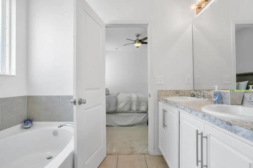 ein weißes Badezimmer mit einer Badewanne und einem Waschbecken in der Unterkunft Large 3 bedroom House ! in Riverview