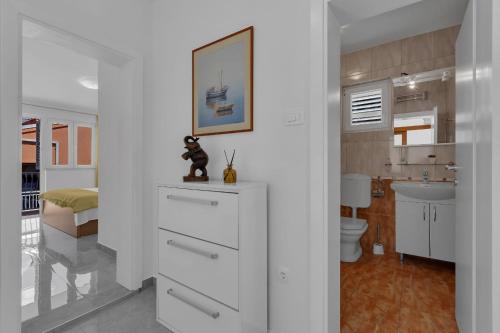 a white bathroom with a sink and a toilet at Ana Apartment in Makarska