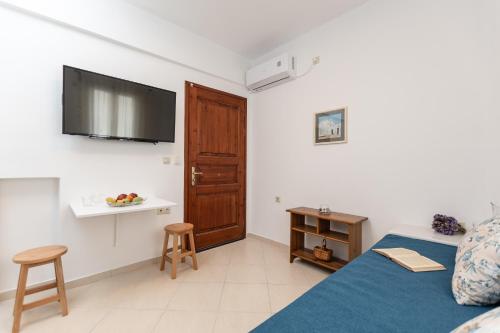Amaranto Naxos 2 في ناكسوس تشورا: غرفة نوم مع سرير وتلفزيون على الحائط
