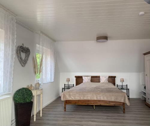a white bedroom with a bed and a window at Ferienwohnung "Möltenorter Strand" in Heikendorf